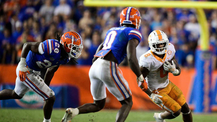 Tennessee running back Tiyon Evans (8) runs the ball as Florida linebacker Ty’Ron Hopper (28) and Florida safety Trey Dean III (0) defend during a game at Ben Hill Griffin Stadium in Gainesville, Fla. on Saturday, Sept. 25, 2021.Kns Tennessee Florida Football