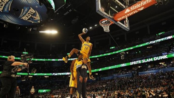 Feb 25, 2012; Orlando, FL, USA; Paul George of the Indiana Pacers completes a dunk as he jumps over Roy Hibbert and Dahntay Jones at the 2012 NBA All-Star Slam Dunk Contest at the Amway Center. Mandatory Credit: Bob Donnan-USA TODAY Sports
