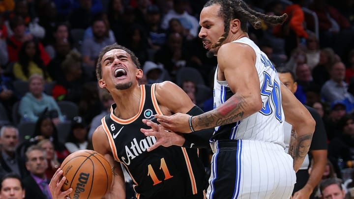 ATLANTA, GEORGIA – DECEMBER 19: Trae Young of the Atlanta Hawks draws a foul as he drives against Cole Anthony of the Orlando Magic. (Photo by Kevin C. Cox/Getty Images)