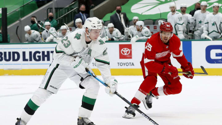 DALLAS, TEXAS - APRIL 19: Esa Lindell #23 of the Dallas Stars controls the puck against Danny DeKeyser #65 of the Detroit Red Wings in the overtime period at American Airlines Center on April 19, 2021 in Dallas, Texas. (Photo by Tom Pennington/Getty Images)