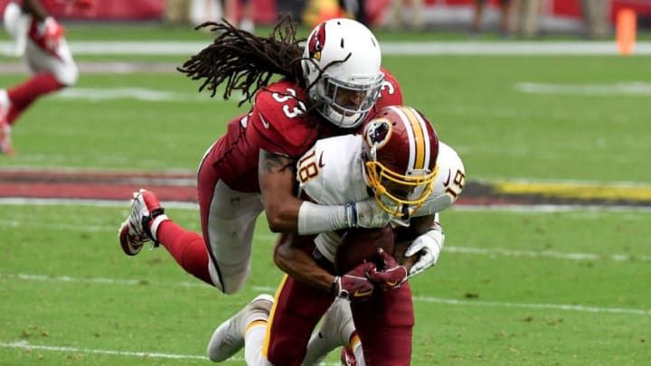 GLENDALE, AZ - SEPTEMBER 9: Defensive back Tre Boston #33 of the Arizona Cardinals tackles wide receiver Josh Doctson #18 of the Washington Redskins during the third quarter at State Farm Stadium on September 9, 2018 in Glendale, Arizona. (Photo by Norm Hall/Getty Images)