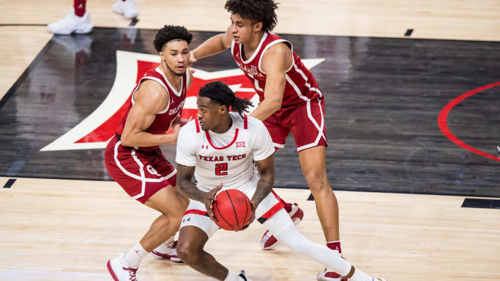 LUBBOCK, TEXAS – FEBRUARY 22: Guard Davion Warren #2 of the Texas Tech Red Raiders handles the ball against guard Jordan Goldwire #0 and forward Jalen Hill #1 of the Oklahoma Sooners during the first half of the college basketball game at United Supermarkets Arena on February 22, 2022 in Lubbock, Texas. (Photo by John E. Moore III/Getty Images)