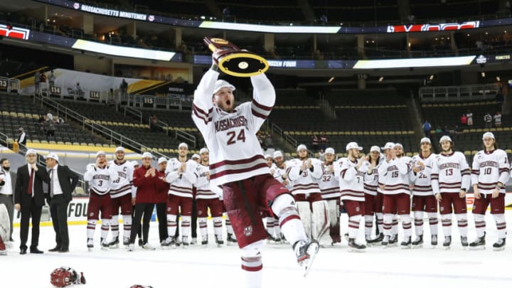 PITTSBURGH, PENNSYLVANIA - APRIL 10: Zac Jones #24 of the Massachusetts Minutemen celebrates with the trophy following the teams 5-0 victory against the St. Cloud St. Huskies to win the Division I Men's Ice Hockey Championship at PPG Paints Arena on April 10, 2021 in Pittsburgh, Pennsylvania. (Photo by Gregory Shamus/Getty Images)