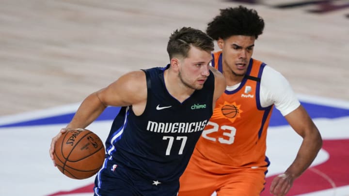 LAKE BUENA VISTA, FLORIDA - AUGUST 02: Luka Doncic #77 of the Dallas Mavericks drives against Cameron Johnson #23 of the Phoenix Suns during the first half at Visa Athletic Center at ESPN Wide World Of Sports Complex on August 2, 2020 in Lake Buena Vista, Florida. NOTE TO USER: User expressly acknowledges and agrees that, by downloading and or using this photograph, User is consenting to the terms and conditions of the Getty Images License Agreement. (Photo by Ashley Landis-Pool/Getty Images)