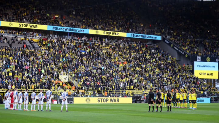 DORTMUND, GERMANY - MARCH 13: Players, officials and fans take part in a minute of silence to indicate peace and sympathy with Ukraine prior to the Bundesliga match between Borussia Dortmund and DSC Arminia Bielefeld at Signal Iduna Park on March 13, 2022 in Dortmund, Germany. (Photo by Christof Koepsel/Getty Images)