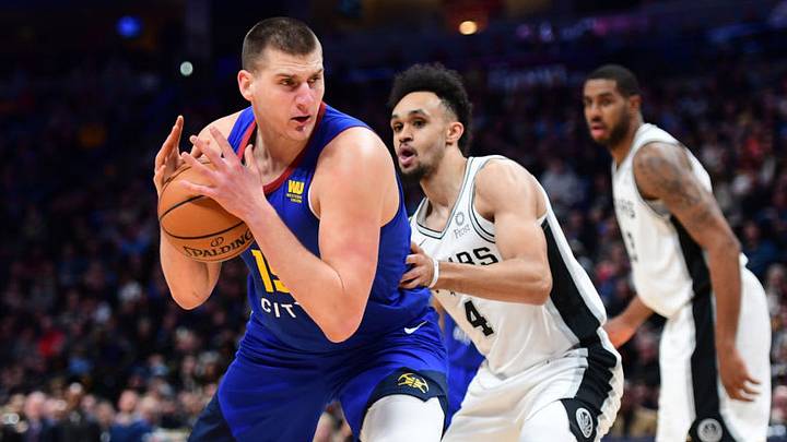 DENVER, CO - DECEMBER 28: Nikola Jokic #15 of the Denver Nuggets drives to the basket against Derrick White #4 of the San Antonio Spurs at Pepsi Center on December 28, 2018 in Denver, Colorado. NOTE TO USER: User expressly acknowledges and agrees that, by downloading and or using this photograph, User is consenting to the terms and conditions of the Getty Images License Agreement. (Photo by Justin Tafoya/Getty Images)