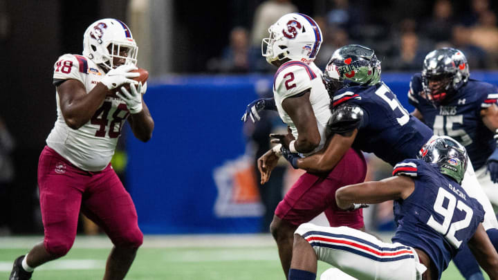 South Carolina State quarterback Corey Fields (2) pitches to tight end Yancey Washington (48) as his is tackled Jackson State linebacker Nyles Gaddy (57) during the Celebration Bowl in Atlanta, Ga., on Saturday December 18, 2021.Cb22