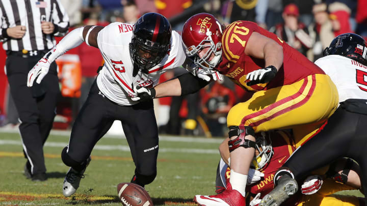Offensive lineman Daniel Burton #70 of the Iowa State Cyclones battles linebacker Sam Eguavoen #13 of the Texas Tech Red Raiders  (Photo by David K Purdy/Getty Images)