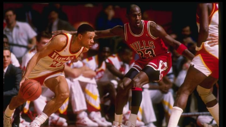 Guard Doc Rivers of the Atlanta Hawks tries to fend off guard Michael Jordan of the Chicago Bulls during a game at the Omni in Atlanta, Georgia.