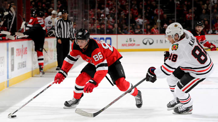 NEWARK, NEW JERSEY - DECEMBER 06: Jack Hughes #86 of the New Jersey Devils takes the puck as Patrick Kane #88 of the Chicago Blackhawks defends at Prudential Center on December 06, 2019 in Newark, New Jersey.The Chicago Blackhawks defeated the New Jersey Devils 2-1 in a shootout. (Photo by Elsa/Getty Images)