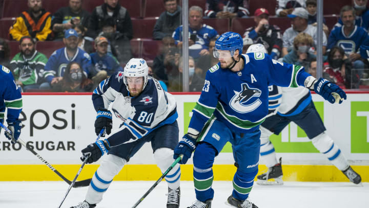 Oct 3, 2021; Vancouver, British Columbia, CAN; Vancouver Canucks defenseman Oliver Ekman-Larsson (23) checks Winnipeg Jets forward Pierre-Luc Dubois (80) in the first period at Rogers Arena. Mandatory Credit: Bob Frid-USA TODAY Sports