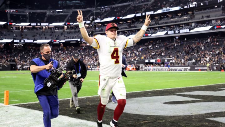 LAS VEGAS, NEVADA - DECEMBER 05: Taylor Heinicke #4 of the Washington Football Team raises his arms as he jogs off the field after the game against the Las Vegas Raiders at Allegiant Stadium on December 05, 2021 in Las Vegas, Nevada. (Photo by Ronald Martinez/Getty Images)