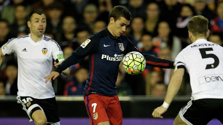 Valencia's midfielder Javi Fuego (L) vies with Atletico Madrid's French forward Antoine Griezmann during the Spanish league football match Club Valencia CF vs Atletico de Madrid at Mestalla stadium in Valencia on March 6, 2016. / AFP / JOSE JORDAN (Photo credit should read JOSE JORDAN/AFP/Getty Images)