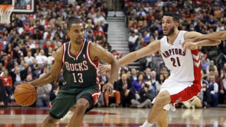 Apr 14, 2014; Toronto, Ontario, CAN; Milwaukee Bucks guard Ramon Sessions (13) tries to get by Toronto Raptors guard Greivis Vasquez (21) at the Air Canada Centre. Toronto defeated Milwaukee 110-100. Mandatory Credit: John E. Sokolowski-USA TODAY Sports