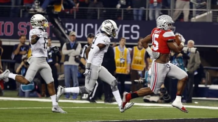 Jan 12, 2015; Arlington, TX, USA; Ohio State Buckeyes running back Ezekiel Elliott (15) scores a touchdown in front of Oregon Ducks defensive back Chris Seisay (12) during the first quarter in the 2015 CFP National Championship Game at AT&T Stadium. Mandatory Credit: Tim Heitman-USA TODAY Sports