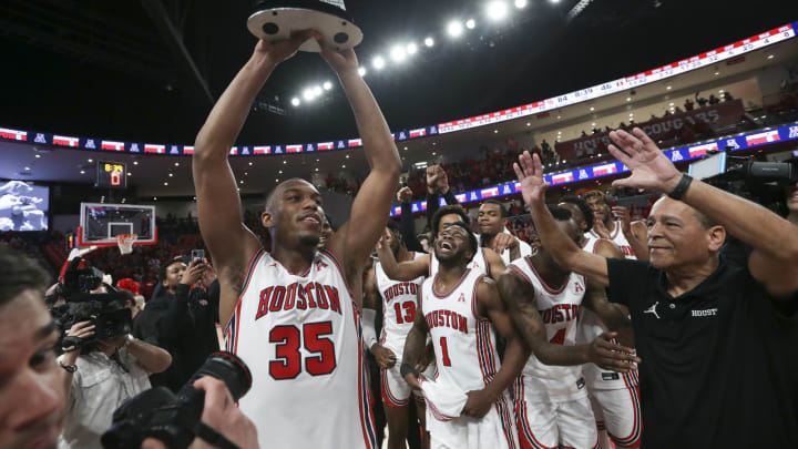 Mar 3, 2022; Houston, Texas, USA; Houston Cougars forward Fabian White Jr. (35) and head coach Kelvin Sampson and teammates celebrate winning the American Athletic Conference after defeating the Temple Owls at Fertitta Center. Mandatory Credit: Thomas Shea-USA TODAY Sports