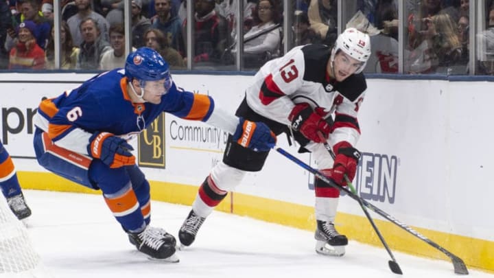 UNIONDALE, NY - JANUARY 02: New Jersey Devils Center Nico Hischier (13) passes the puck with New York Islanders Defenseman Ryan Pulock (6) defending during the third period of the National Hockey League game between the New Jersey Devils and the New York Islanders on January 2, 2020, at the Nassau Veterans Memorial Coliseum in Uniondale, NY. (Photo by Gregory Fisher/Icon Sportswire via Getty Images)