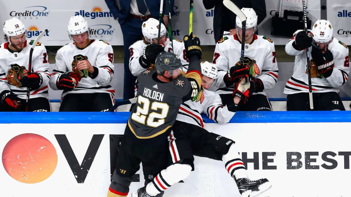 Nick Holden #22 of the Vegas Golden Knights hits Matthew Highmore #36 of the Chicago Blackhawks into the boards