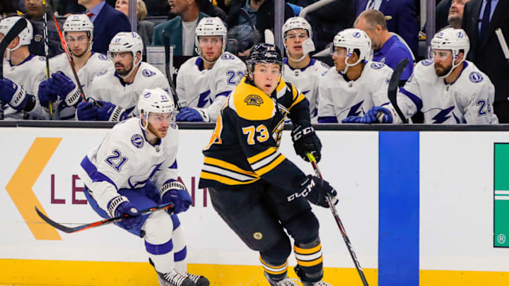 BOSTON, MA - OCTOBER 17: Boston Bruins defenseman Charlie McAvoy (73) skates with the puck as Tampa Bay Lightning center Brayden Point (21) trails the play near Lightning bench during the Tampa Bay Lightning and Boston Bruins NHL game on October 17, 2019, at TD Garden in Boston, MA. (Photo by John Crouch/Icon Sportswire via Getty Images)