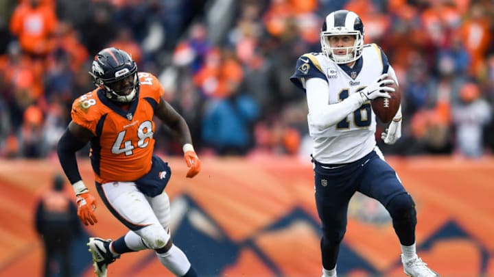 DENVER, CO - OCTOBER 14: Quarterback Jared Goff #16 of the Los Angeles Rams rushes for a first down as linebacker Shaquil Barrett #48 of the Denver Broncos chases in the fourth quarter of a game at Broncos Stadium at Mile High on October 14, 2018 in Denver, Colorado. (Photo by Dustin Bradford/Getty Images)