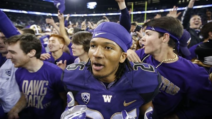 Sep 30, 2016; Seattle, WA, USA; Washington Huskies defensive back Sidney Jones (26) celebrates as students rush the field after a game against the Stanford Cardinal Husky Stadium. Washington won 44-6. Mandatory Credit: Jennifer Buchanan-USA TODAY Sports