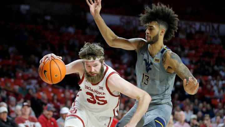 Oklahoma Sooners forward Tanner Groves (35) goes past West Virginia Mountaineers forward Isaiah Cottrell (13) during a men's Big 12 basketball game between the University of Oklahoma Sooners (OU) and the West Virginia Mountaineers at Lloyd Noble Center in Norman, Okla., Tuesday, March 1, 2022. Oklahoma won 72-59.Ou Vs West Virginia