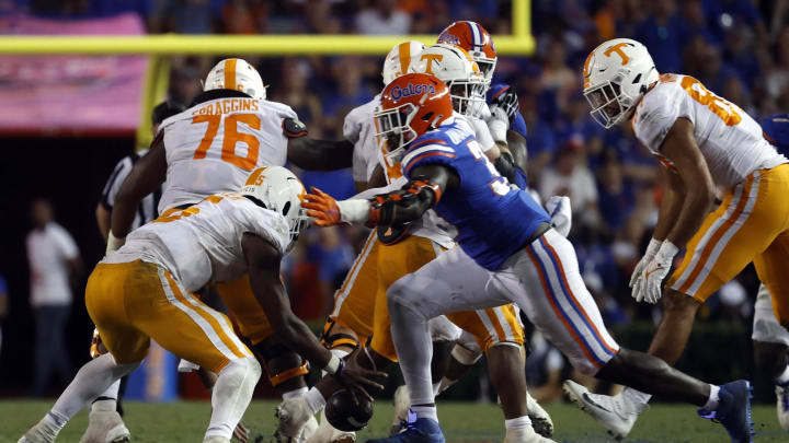 Sep 25, 2021; Gainesville, Florida, USA;Tennessee Volunteers quarterback Hendon Hooker (5) fumbles the ball as Florida Gators defensive lineman Princely Umanmielen (33) defends during the fourth quarter at Ben Hill Griffin Stadium. Mandatory Credit: Kim Klement-USA TODAY Sports