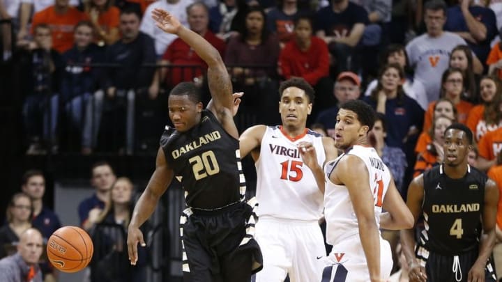 Dec 30, 2015; Charlottesville, VA, USA; Virginia Cavaliers guard Malcolm Brogdon (15) and forward Isaiah Wilkins (21) knock the ball away from Oakland Golden Grizzlies guard Kay Felder (20) during the second half at John Paul Jones Arena. The Cavaliers won 71-58. Mandatory Credit: Amber Searls-USA TODAY Sports
