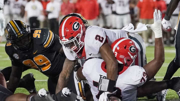 Oct 1, 2022; Columbia, Missouri, USA; Georgia Bulldogs running back Kendall Milton (2) scores against Missouri Tigers defensive back Jaylon Carlies (1) and linebacker Dameon Wilson (10) during the second half at Faurot Field at Memorial Stadium. Mandatory Credit: Denny Medley-USA TODAY Sports