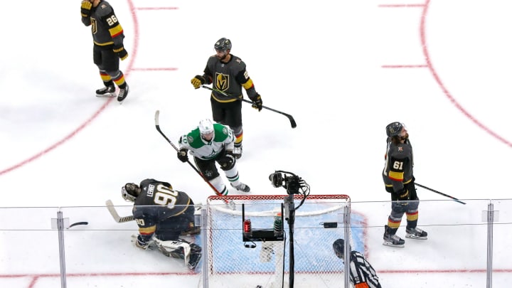 Corey Perry #10 of the Dallas Stars retrieves the game winning puck after an overtime win against Robin Lehner #90 and the Vegas Golden Knights