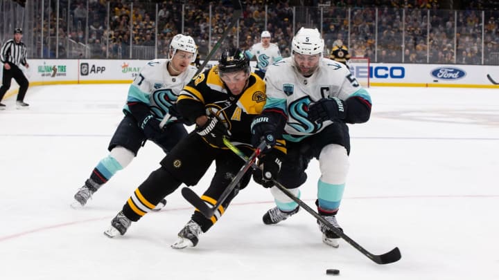 BOSTON, MA – FEBRUARY 1: Brad Marchand, #63 of the Boston Bruins, checks Mark Giordano, #5 of the Seattle Kraken, during the third period at the TD Garden on February 1, 2022, in Boston, Massachusetts. The Bruins won 3-2. (Photo by Rich Gagnon/Getty Images)