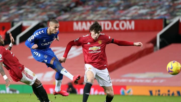 Everton's Brazilian striker Richarlison (C) shoots past Manchester United's Brazilian midfielder Fred (L) and Manchester United's Swedish defender Victor Lindelof during the English Premier League football match between Manchester United and Everton at Old Trafford in Manchester, north west England, on February 6, 2021. (Photo by Alex Pantling / POOL / AFP) / RESTRICTED TO EDITORIAL USE. No use with unauthorized audio, video, data, fixture lists, club/league logos or 'live' services. Online in-match use limited to 120 images. An additional 40 images may be used in extra time. No video emulation. Social media in-match use limited to 120 images. An additional 40 images may be used in extra time. No use in betting publications, games or single club/league/player publications. / (Photo by ALEX PANTLING/POOL/AFP via Getty Images)