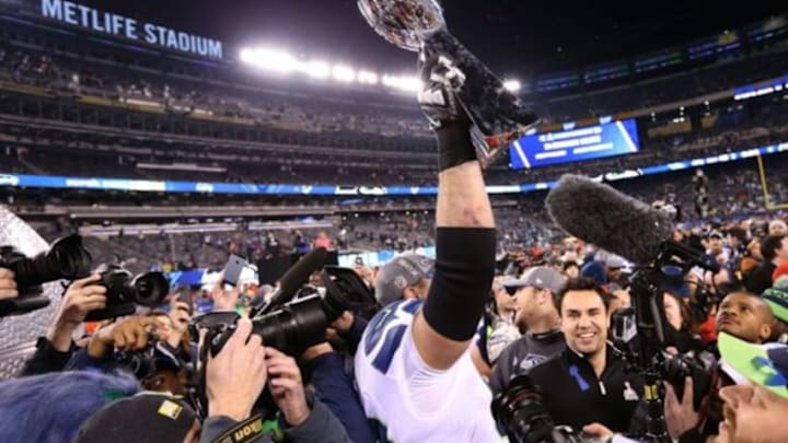 Feb 2, 2014; East Rutherford, NJ, USA; Seattle Seahawks tackle Breno Giacomini (68) celebrates as he hoist the Lombardi Trophy against the Denver Broncos at MetLife Stadium. Seattle Seahawks won 43-8. Mandatory Credit: Matthew Emmons-USA TODAY Sports