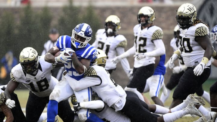 DURHAM, NORTH CAROLINA - NOVEMBER 24: Defensive back Cameron Glenn #2 of the Wake Forest Demon Deacons leads a tackle of running back Deon Jackson #25 of the Duke Blue Devils during their football game at Wallace Wade Stadium on November 24, 2018 in Durham, North Carolina. (Photo by Mike Comer/Getty Images)