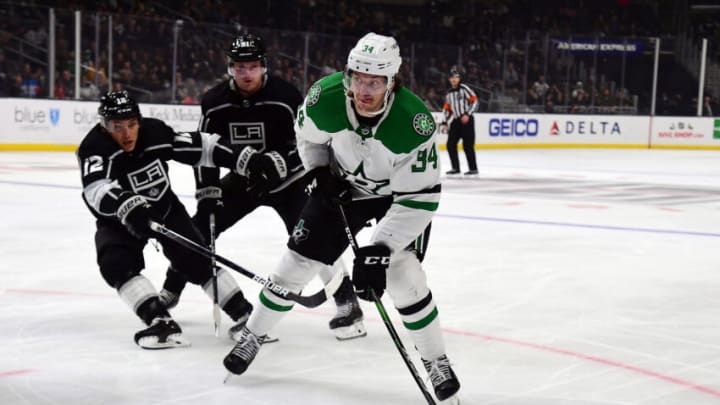 Dec 9, 2021; Los Angeles, California, USA; Dallas Stars right wing Denis Gurianov (34) moves the puck against Los Angeles Kings center Trevor Moore (12) during the third period at Staples Center. Mandatory Credit: Gary A. Vasquez-USA TODAY Sports