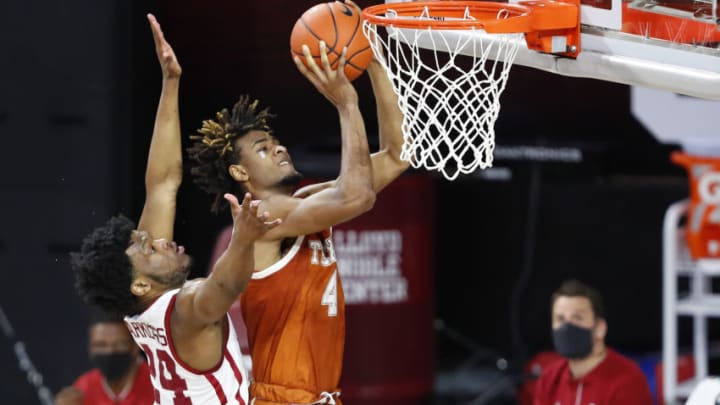 Mar 4, 2021; Norman, Oklahoma, USA; Texas Longhorns forward Greg Brown (4) shoots as Oklahoma Sooners guard Elijah Harkless (24) defends during the first half at Lloyd Noble Center. Mandatory Credit: Alonzo Adams-USA TODAY Sports
