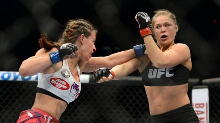 Dec 28, 2013; Las Vegas, NV, USA; Ronda Rousey (red gloves) and Miesha Tate (blue gloves) during their UFC Women