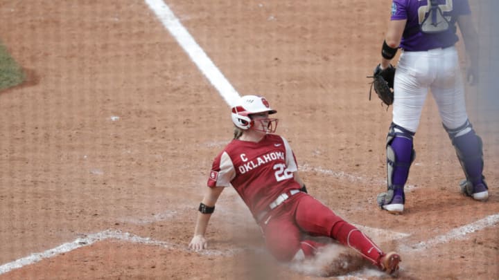 Jun 7, 2021; Oklahoma City, Oklahoma, USA; Oklahoma catcher Lynnsie Elam (22) slides across home plate to score a run against James Madison in the fourth inning of an NCAA WomenÕs College World Series semi final game at USA Softball Hall of Fame Stadium. Mandatory Credit: Alonzo Adams-USA TODAY Sports
