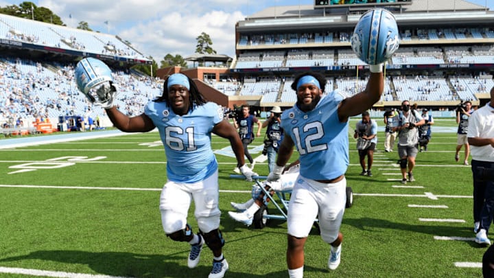 Oct 2, 2021; Chapel Hill, North Carolina, USA; North Carolina Tar Heels offensive lineman Diego Pounds (61) and linebacker Tomon Fox (12) pull the Victory Bell after the game at Kenan Memorial Stadium. Mandatory Credit: Bob Donnan-USA TODAY Sports