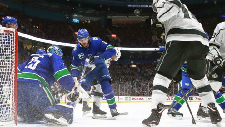 VANCOUVER, BC - OCTOBER 9: Jacob Markstrom #25 of the Vancouver Canucks and Christopher Tanev #8 of the Vancouver Canucks and Alex Iafallo #19 of the Los Angeles Kings watch a loose puck during their NHL game at Rogers Arena October 9, 2019 in Vancouver, British Columbia, Canada. (Photo by Jeff Vinnick/NHLI via Getty Images)"n