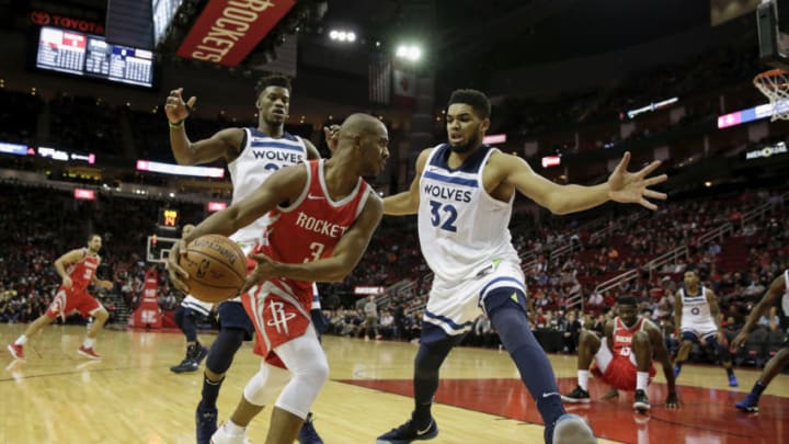 HOUSTON, TX - JANUARY 18: Chris Paul #3 of the Houston Rockets controls the ball on the baseline defended by Karl-Anthony Towns #32 of the Minnesota Timberwolves and Jimmy Butler #23 in the first half at Toyota Center on January 18, 2018 in Houston, Texas. NOTE TO USER: User expressly acknowledges and agrees that, by downloading and or using this Photograph, user is consenting to the terms and conditions of the Getty Images License Agreement. (Photo by Tim Warner/Getty Images)
