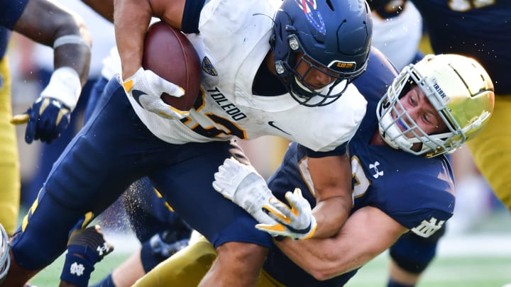 Sep 11, 2021; South Bend, Indiana, USA; Toledo Rockets running back Bryant Koback (22) is tackled by Notre Dame Fighting Irish linebacker JD Bertrand (27) in the fourth quarter at Notre Dame Stadium. Mandatory Credit: Matt Cashore-USA TODAY Sports