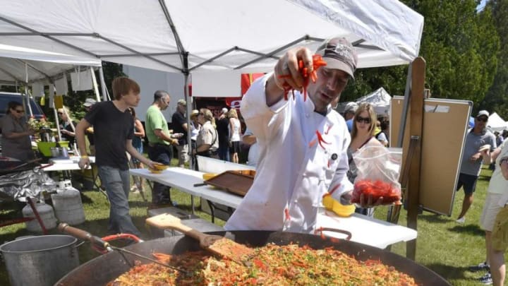 Scott McEvoy of McEvoy's Culinaria of Sister Bay adds peppers to paella prepared in an oversized wok during last year's Uncork Summer in Ellison Bay.Dcn 0619 Uncork Summer Cover