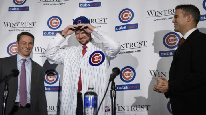 CHICAGO, IL - DECEMBER 15: Pitcher Jon Lester (C) puts on a Cubs hat during an introduction press conference as Chicago Cubs President Theo Epstein (R) and general manager Jed Hoyer looks on on December 15, 2014 in Chicago, Illinois. (Photo by David Banks/Getty Images)