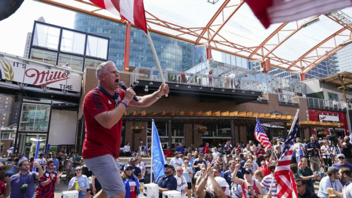 Jun 16, 2022; Kansas City, Missouri, USA; Radio personality Nate Bukaty waves the American flag during a watch party for the announcement of the FIFA World Cup 2026 host cities at Power & Light District. Mandatory Credit: Jay Biggerstaff-USA TODAY Sports
