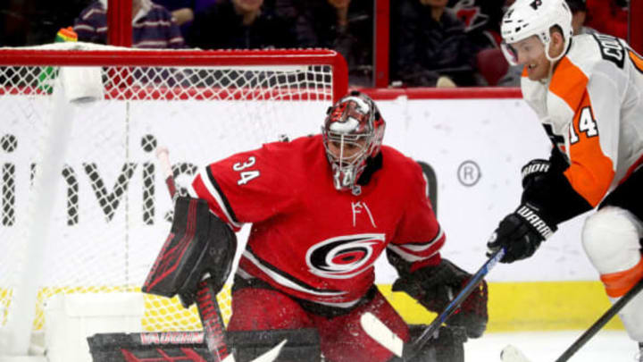 RALEIGH, NC – MARCH 30: Petr Mrazek #34 of the Carolina Hurricanes deflects the puck away from the crease on an attempt by Sean Couturier #14 of the Philadelphia Flyers during an NHL game on March 30, 2019 at PNC Arena in Raleigh, North Carolina. (Photo by Gregg Forwerck/NHLI via Getty Images)