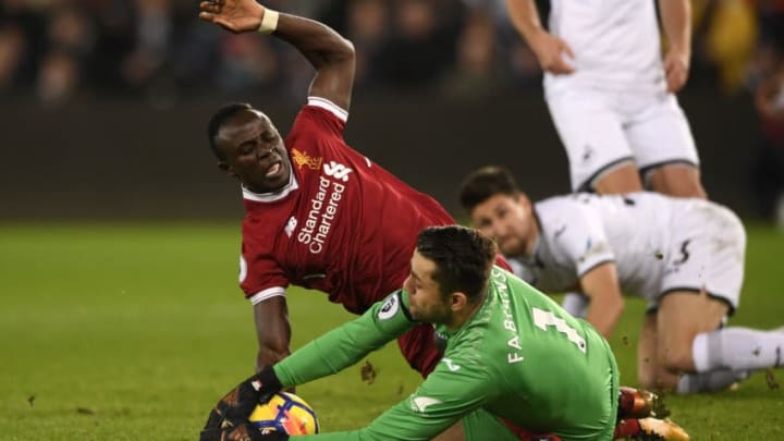 SWANSEA, WALES - JANUARY 22: Sadio Mane of Liverpool and Lukasz Fabianski of Swansea City clash during the Premier League match between Swansea City and Liverpool at Liberty Stadium on January 22, 2018 in Swansea, Wales. (Photo by Stu Forster/Getty Images)
