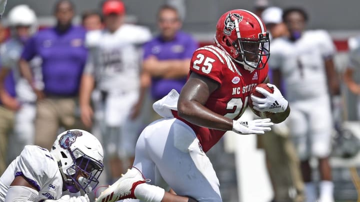 RALEIGH, NC – SEPTEMBER 01: John Daka #97 of the James Madison Dukes tackles Reggie Gallaspy II #25 of the North Carolina State Wolfpack during their game at Carter-Finley Stadium on September 1, 2018 in Raleigh, North Carolina. (Photo by Grant Halverson/Getty Images)