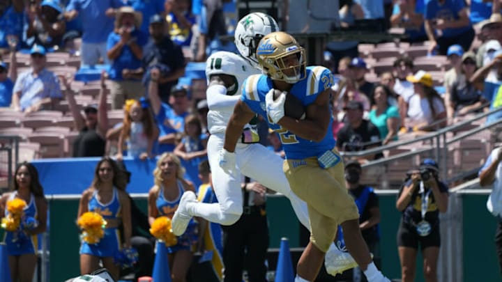 Aug 28, 2021; Pasadena, California, USA; UCLA Bruins running back Zach Charbonnet (24) is defended by Hawaii Rainbow Warriors linebacker Penei Pavihi (1) and defensive back Cortez Davis (18) on a 21-yard touchdown run in the first quarter at Rose Bowl. Mandatory Credit: Kirby Lee-USA TODAY Sports