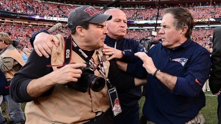 January 19, 2014; Denver, CO, USA; New England Patriots head coach Bill Belichick pushes photographer Damian Strohmeyer following the 26-16 loss to the Denver Broncos in the 2013 AFC Championship football game at Sports Authority Field at Mile High. Mandatory Credit: Ron Chenoy-USA TODAY Sports